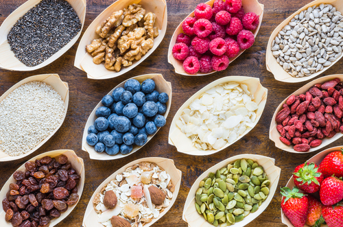 various superfoods on wood table top