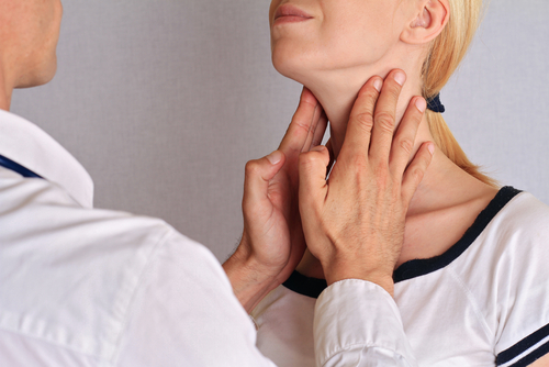 doctor feeling patients thyroid glands