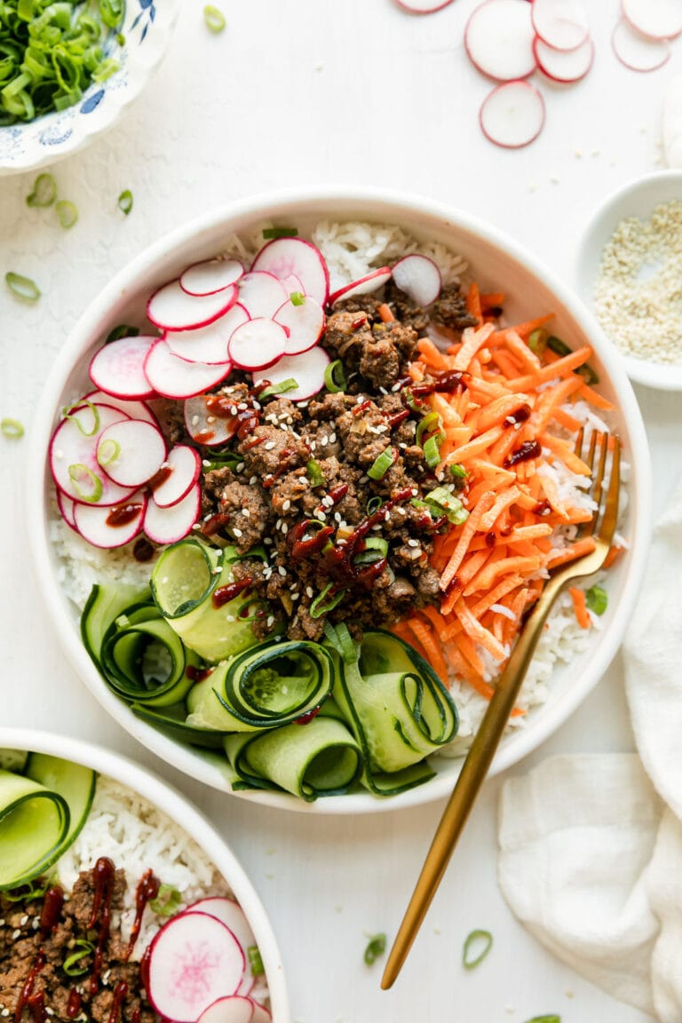 Overhead view of Korean-inspired Ground Beef Bowl served over rice in white bowl.