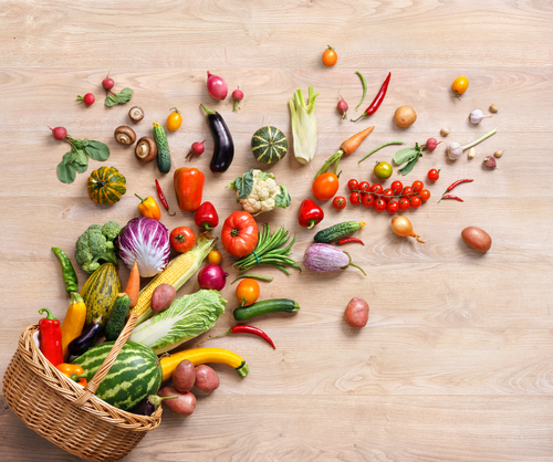 assorted fruits and vegetables spilling out of basket