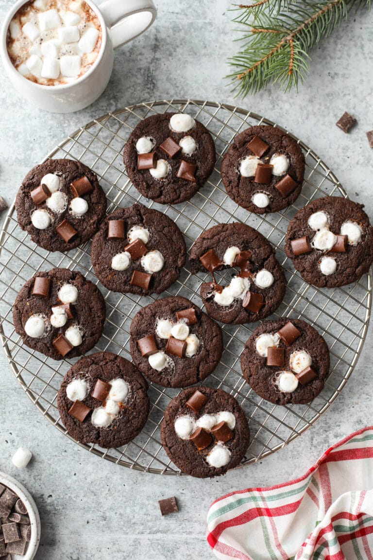 Round wire rack filled with Mexican hot chocolate cookies topped with melted mini marshmallows and chocolate chunks.