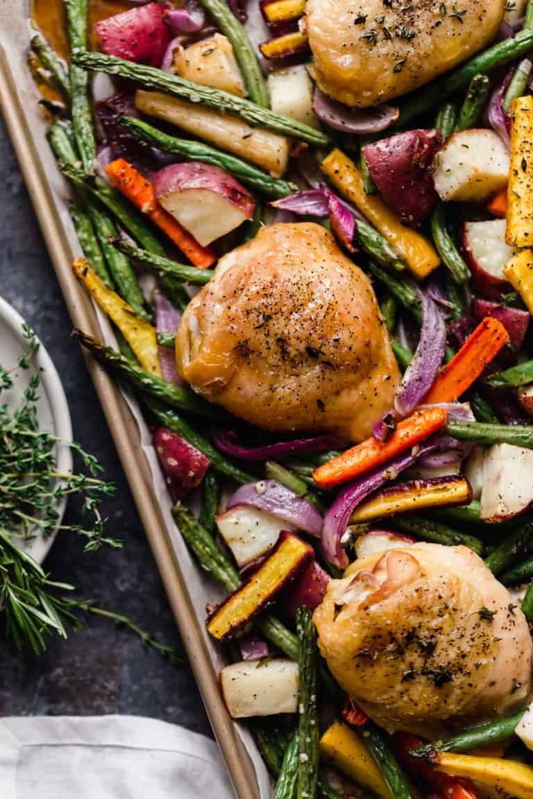 Overhead view sheet pan chicken thighs and vegetables.